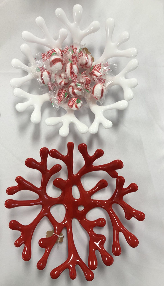 Two coral-shaped fused glass bowls, one in white and one in red, with a delicate branching design, filled with peppermint candies in the white bowl.