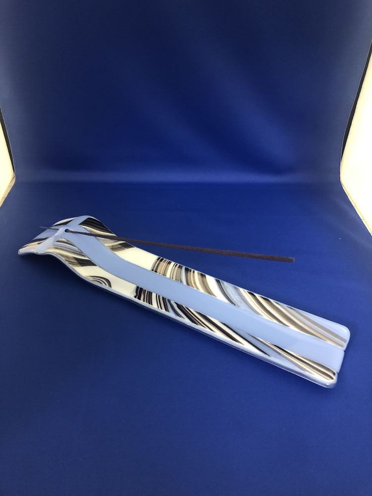 A long, narrow fused glass incense burner with a striped pattern in blue and white, designed to catch ash and create a peaceful atmosphere.